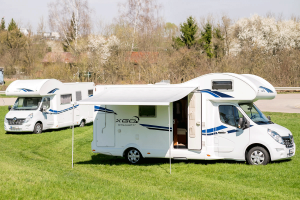 Logo von Magia Wohnmobile – Wohnmobilvermietung in Rheinmünster - zwei Wohnmobile auf grüner Wiese