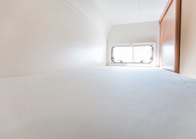 Innenansicht eines Wohnmobils zur Miete bei Magia Wohnmobile in Rheinmünster – Große Alkoven mit Schlafbereich